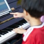 girl teach boy piano