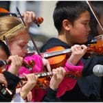kids playing violin in orchestra